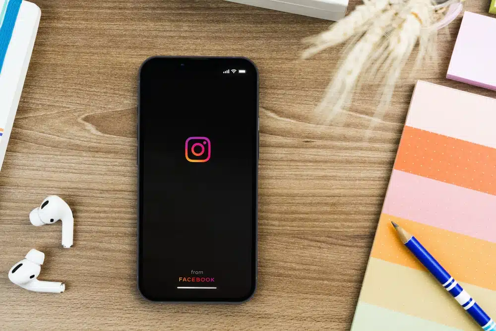 A smartphone displaying the Instagram app with a downward arrow symbol.
