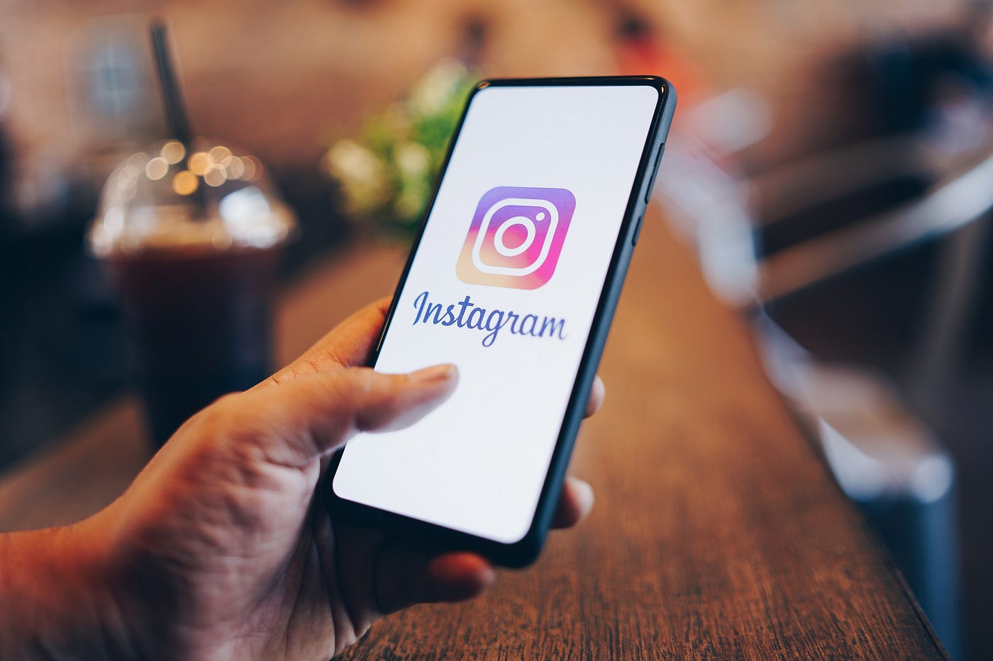 A laptop displaying social media icons with a magnifying glass hovering over the Instagram logo.