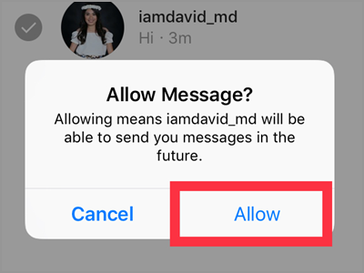 A person holding a smartphone, viewing an Instagram profile with the message icon highlighted.